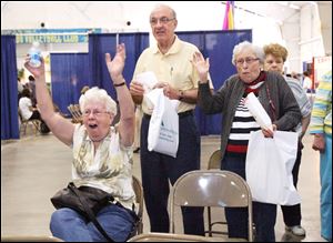 Rose Tiller, left, of Temperance celebrates herhusband s skill with the Nintendo Wii Fit game as Paul and Betty Lehman of Toledo watch at the 32nd annual Senior Day Spring Fling, at the Lucas County Recreation Center yesterday.