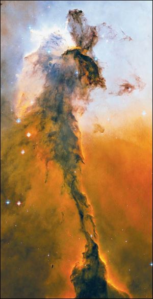 This 2005 image of the Eagle Nebula reveals a tall, dense tower of gas being sculpted by ultraviolet light from a group of massive stars.