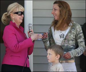 Carol Johns presents the keys to the new house in Monroe to Julie Payne and her son Hunter.