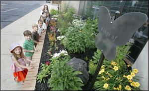 Students, from front, Emma Stammen, 6, Jack Fretti, 6, Joey Hoppenjans, 6, Nick Aubry, 10, Eric Aubry, 10, Hannah Withrow,10, Sydni Witton, 12, and Grace Shade, 11, learn about monarch butterflies and the flowers that attact them to the  Wings of Heaven  butterfly station.