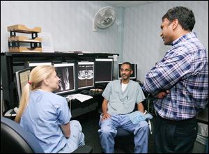 From left, Drs. Teppe Popovich, Kenneth Cook, and Ramesh Avna, of Imaging Advantage, discuss a case at St. Vincent Mercy Medical Center.