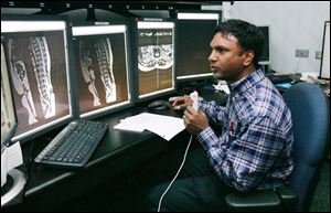 Dr. Ramesh Avna records his findings from a group of images at St. Vincent Mercy Medical Center. The hospital dropped its longtime local radiology provider for a California company.