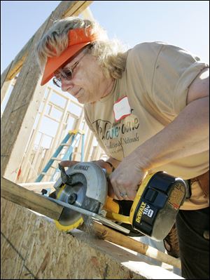 NBRE habitat01p  06/26/09  The Blade/Dave Zapotosky Caption: Vicki Shutters of Swanton cuts a board at a Habitat for Humanity build on Ansonia St. in Oregon, Ohio, Friday, June 26, 2009.  Two homes were being constructed by a large group of volunteers including some from five are religious congregations, the United Way Women's Initiative, and the National Association of Women in Construction (NAWIC), Toledo Chapter.   Summary: Habitat for Humanity build in Oregon.