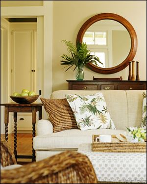 Front view of a sofa and a circular mirror seen in the living room