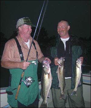 Western Lake Erie yields walleyes which brings smiles to charter boat skipper Dan Tucker, left, and Toledo angler Jim Kaiser. Some of their success is tied to slowly drifting over reefs.