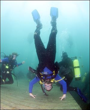 Slug: CTY gilboa19p Date:   07172009       The Blade/Andy Morrison       Location: Gilboa    Caption: A diver stands on his hands as he and others try to set the world record for most divers submerged at Gilboa Quarry, Saturday, 07182009.