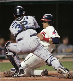 Victor Martinez scores Cleveland's lone run in the seventh inning despite a tag attempt from Mariners catcher Rob Johnson.