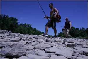 ROV drybed  07/14/2009     The Blade/Lori King  Eric Valentine, of Holland, left, and Perrysburg resident Andrew Zaletel walk on the dry stone bed of the Maumee River at SideCut Metropark in Maumee , OH. Little rain has fell this month, and river and creek beds are drying up as a result.