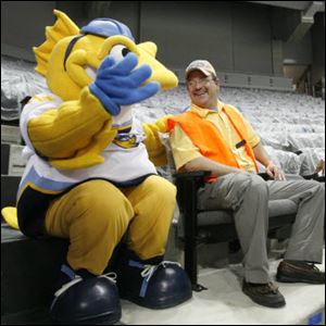 Walleye mascot, Spike, visits with Mark Hummer, a season ticket holder who was the first person to sit in a seat at the Lucas County Arena yesterday.