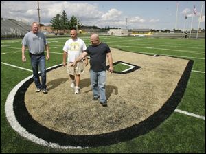 Perrysburg assistant athletic director Dave Hall, center, checks out the new stadium surface with Maumee Bay Turf Company's Brad Morrison, left, and P.J. Kapfhammer.