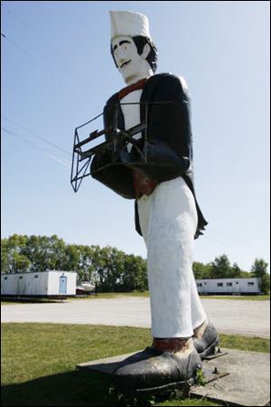 At right: ‘Giant Jacques,' an armless French waiter, stands along State Rt. 163 in Marblehead. The statue once held a sandwich.