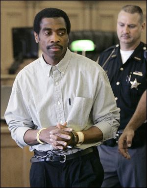 Michael Dixon, 52, is escorted in the Wood County Common Pleas Court. Dixon was convicted on charges he raped and fatally stabbed Karen Sue Hirschman in her off-campus residence 22 years ago.