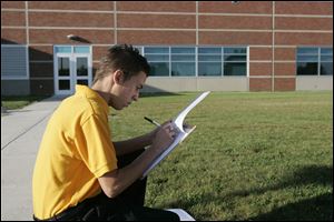 Jonathon Balcerzak, 16, rights down the distance from where he used the clinometer to the base of the building measured. 