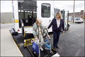 TARPS driver Kerrie Houk assists Bea Jennings as she exits one of the Toledo Area Paratransit Service's buses. Ms. Jennings suffers from severe arthritis.