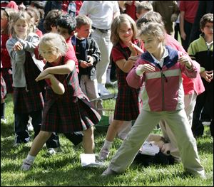 Kiri Thibert, left, and Amelia Maibach, first graders at Sylvania Franciscan Academy, do the 'Earth Worm Dance' following the Blessing of the Animals at Lourdes College.