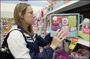 Amy Reimer of Millbury, Ohio, shops for toys at the Meijer on Wheeling Street in Oregon. The chain, which discounted 300 popular toys last holiday season, added 100 to the list this year.