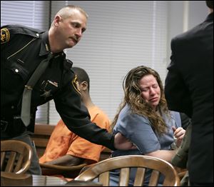 The Blade/Dave Zapotosky Sarah Bunch is subdued by a Wood County sheriff's deputy after her emotional outburst upon learning she will serve 13 years in prison for killing a Northwood man and setting his house on fire.