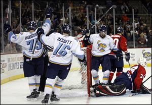 Toledo's Justin Hodgman (75), Derek Nesbitt (16) and Chris Robertson celebrate Hodgman's goal.