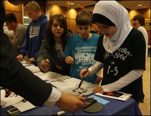 Springfield Middle School students, from right, Zainab Hussein, Andrew Jacobs, Tiffany Osborn, and Ben Baumgartner practice Chinese calligraphy at the Chinese Lantern Festival Carnival at the University of Toledo. Yesterday's event on Chinese culture was sponsored by the Confucius Institute at UT.
<br>
<img src=http://www.toledoblade.com/graphics/icons/photo.gif> <font color=red><b>PHOTO GALLERY</b></font>: <a href=