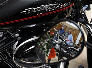 Slug: CTY harley01p Date:  02282010     Andy Morrison       Location: Toledo  Caption: Wayne Smith and Jan Gibson, Holland, are reflected in a mirror as they check out the bikes on display at Westfield Franklin Park Mall at the Toledo Harley Owners Group, Chapter 1524's 17th Annual Motorcycle Show and Raffle, Sunday, 02282010. Summary.