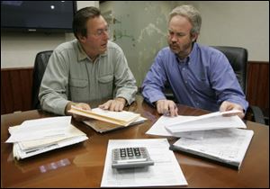 David Friedman, a retired doctor, left, goes over his paperwork with Steve Schult, a tax partner with Gilmore, Jasion & Mahler Ltd., at the certified public accounting firm's offices in Maumee.