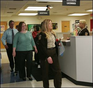 Acting Lucas County Dog Warden Bonnie Mitchell, right, gives Julie Lyle, center, a candidate for the dog warden position, a tour of the facilities along with Lucas County Commissioner Pete Gerken.