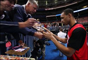 Ohio State's Evan Turner signs autographs after a practice session in St. Louis.