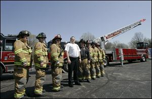 Standing before the Sylvania Township fire department's new pumper and aerial ladder trucks are, from left, firefighter/paramedics Doug Born, Patrick Miller, Lt. Mike Ramm, Assistant Chief Jeff Kowalski, Dean Boyers, Tim Osborn, Darrell Elliott, and Lt. Steve Steinmetz.