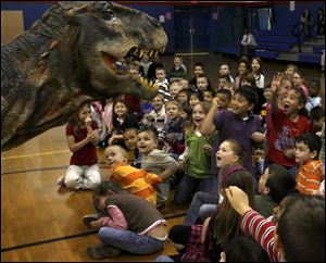 NBRS dino05p   Holland Elementary School first and second Grade students with a baby tyrannosaurus rex at the Holland, Ohio school on April 26, 2010. Holland Elementary School First and Second Grade students and staff were selected to receive a visit from a baby T-Rex from the Walking With Dinosaurs show. Jetta Fraser/Toledo Blade