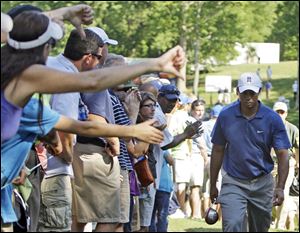 Fans give Tiger Woods a thumbs down as he leaves the 15th hole during the second round of the Quail Hollow Championship in Charlotte Friday.