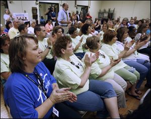 Edith Keeler, left, applauds with other teachers at the board meeting. The single-sex academies have gained praise.