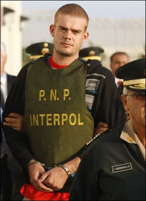 Joran Van der Sloot, top, is escorted by police officers outside a Peruvian police station, near the border with Chile in Tacna, Peru, Friday, June 4, 2010.