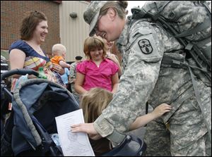 Spc. Amanda English of Perrysburg gets a hug from Alexis Gallagher, 4, of Millbury. Behind them are, from left, Alexis' mother, Theresa Emerick, holding 7-month-old Steven Fowler, and Shelbylee Hoff, 8, of Moline.