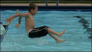 Kaleb Mosher, 8, hits the water in the Walbridge pool on opening day.