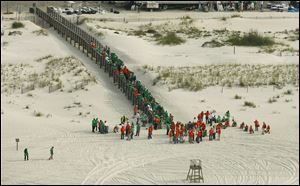 Oil cleanup workers gather for duty in Orange Beach, Ala., as efforts continue to control the gusher in the Gulf of Mexico. BP is establishing a $20 billion fund to pay claims arising from the spill.