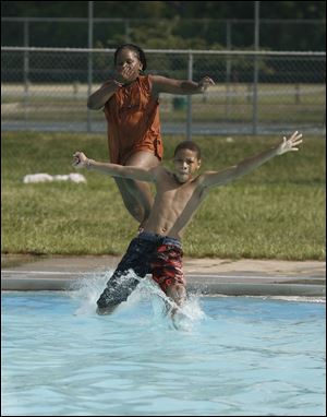 Tireesea Taylor, 11, left, follows Malik Hinton, 11, into the pool at Willys Park in West Toledo. The high Wednesday was 94.