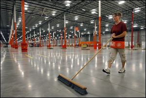 Kristen Lasley sweeps the floor in preparation for the grand opening of the Home Depot regional distribution center in Van Buren, Ohio, north of Findlay.