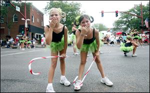 Elsewhere on the parade route Haley Barber, left, and Haley Trevino of Dance Expressions in Maumee perform a routine complete with canes made to look like - despite it being a 'summer' fair - a Christmas treat.