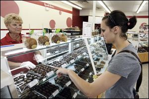 Bonnie Lymond helps Christine Ost of Deefield, Mich., make a selection at the Russell Stover store that opened near Cabela's six years ago.