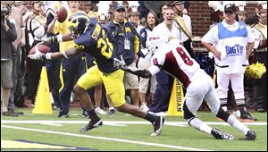 Michigan's Darryl Stonum (22) pulls away from Massachusetts defensive back Mike Lee for a touchdown in the second quarter. 