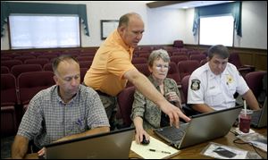 In Sylvania Township, specialist Mike Tans instructs municipal employees, from left, Greg Huffman, Nancy Beckmann, and Rob Boehme in the new computer system.