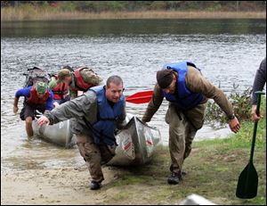 Paramedic Todd Metcalf, left, of Northwood and team member Tim McCormick of Lyons, Ohio, drag their canoe out of Pickerel Lake during the Midwest MedWAR in Pinckey, Mich. 