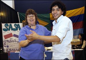 CTY international09p  Toledo resident Donna Eckloff (cq), left, dancing with Eduardo Diaz (cq), president of the South American Students Association in front of their table. The 19th annual food festival presented by the International Students Association at the University of Toledo in Toledo, Ohio on October 8, 2010. Jetta Fraser/The Blade