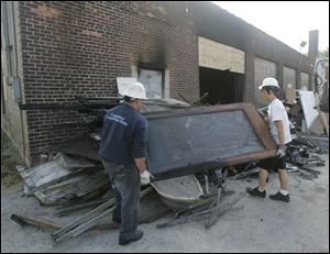 Jorge Duran, left, and Dylan Dunbar remove fire-damaged supplies from Habitat for Humanity's office on South Fearing. The blaze broke out Sunday and caused at least $200,000 in damage.