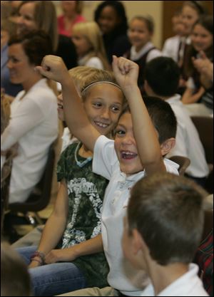 CTY pigkisser11  Second graders Miranda Sullivan, left, and Caiden (cq) Guzman in anticipation of the the principal's kissing of a pig. Principal Jayne Swemba, of the K-8 Catholic school St. Joan D'Arc, kisses a pig as promised after the students met the fund-raising goal from magazine subscription sales, at the school in Toledo, Ohio on October 11, 2010.  Jetta Fraser/The Blade