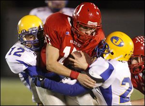 Bedford's Jared Kujawa draws Monroe Jefferson tacklers Jacob Sterling, left, and Eric Morrow. The Mules will enter the playoffs with a 9-0 record.<br>
<img src=http://www.toledoblade.com/graphics/icons/photo.gif> <font color=red><b>VIEW GALLERY:</b></font> <a href=