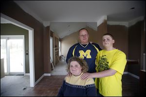 Beth, Scott, and Byron Swartz, currently in temporary quarters in Oregon, stop by their new home daily to check on progress there. The scheduled completion date is Nov. 15.