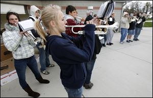 Trumpeting in occasion with music is Tiffany Chumley, 14, and other members of the school's marching band.