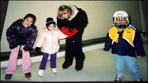 In this photo from 2003, Monica Jablonski is on the ice with Sarah, left, Cate, and Matthew Orchard. A native of British Columbia, Mrs. Jablonski, 71, of Springfield Township taught the basics of ice skating to multiple generations of local youngsters.