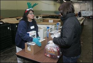 CTY islamic22p  The Blade/Lori King  12/22/2010  Seagate Food Bank staffer Delores Reyes hands out free holiday dinners at the Toledo Seagate Food Bank in Toledo, Ohio.